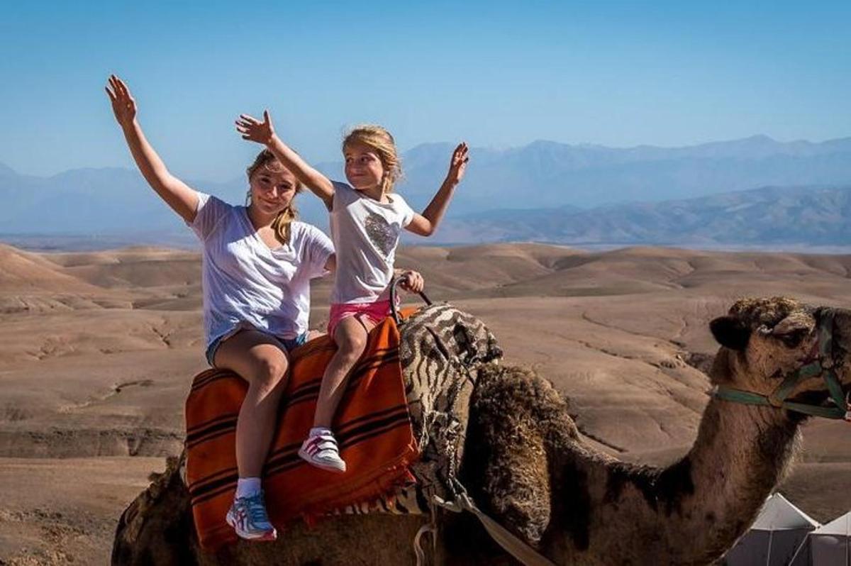 two people riding on the back of a camel