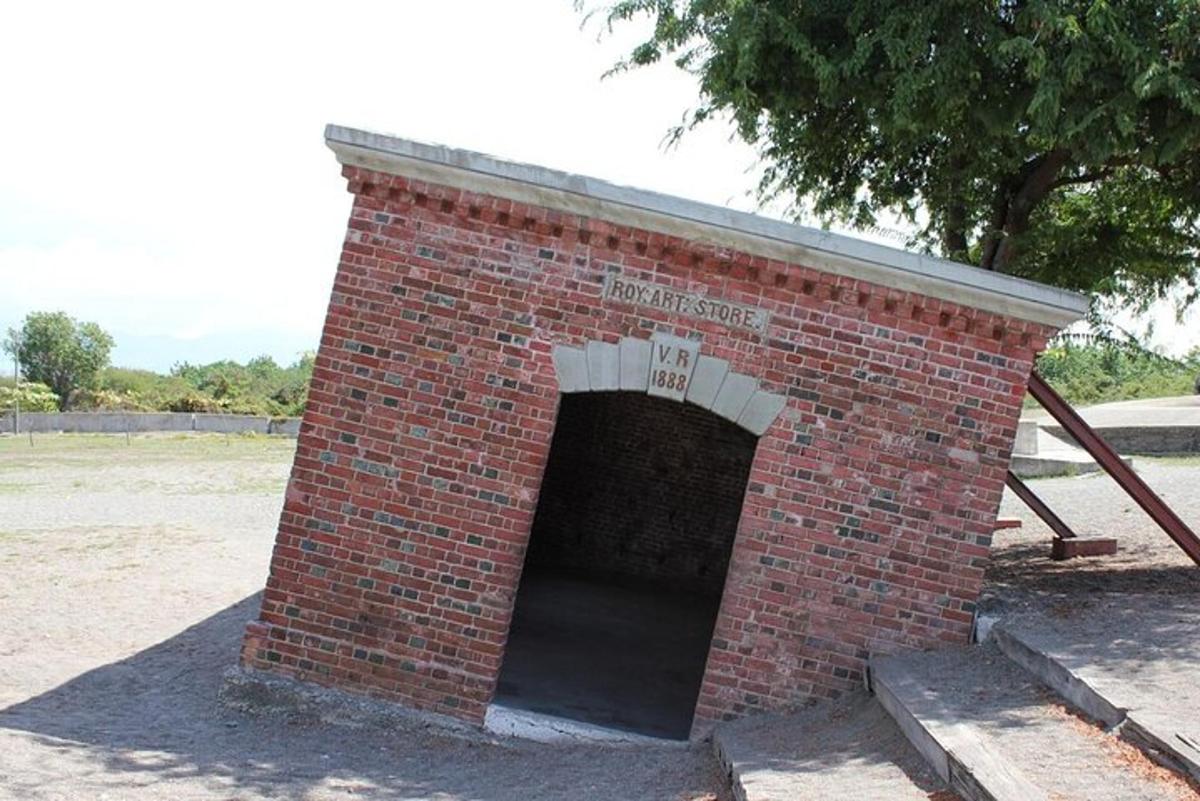 un edificio in mattoni rossi con un tunnel in un campo