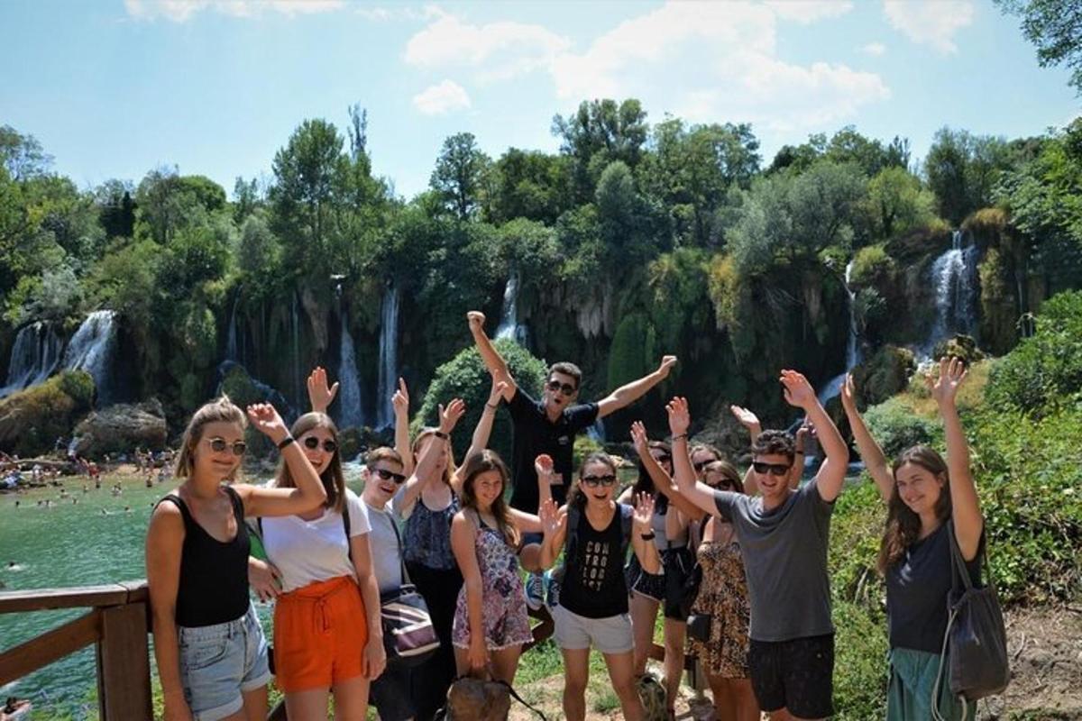 a group of people standing in front of a waterfall