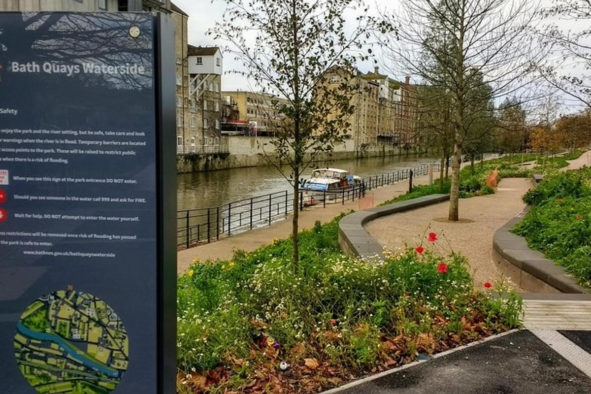 a sign in a park next to a river