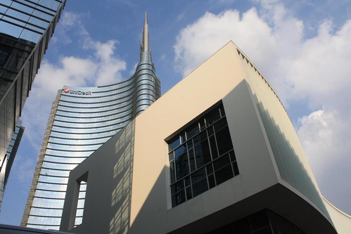 un edificio con una guglia accanto a un edificio alto