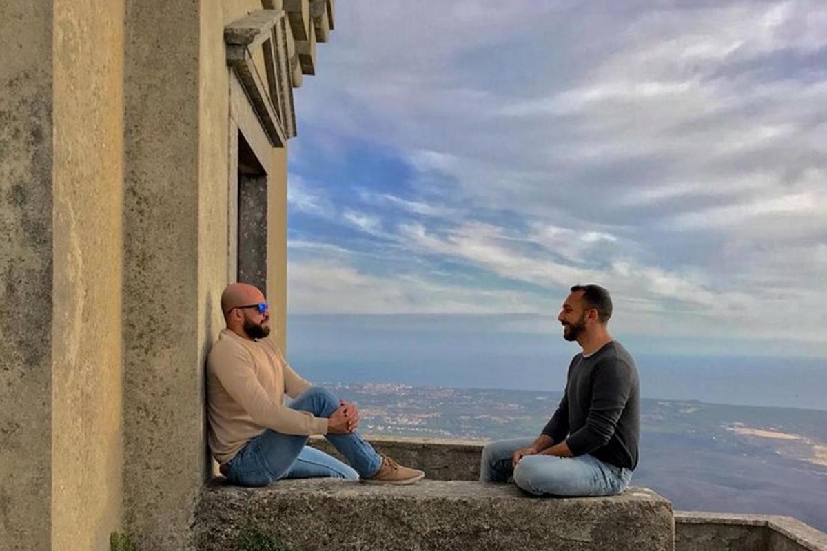 δύο άντρες κάθονται στο περβάζι ενός κτιρίου