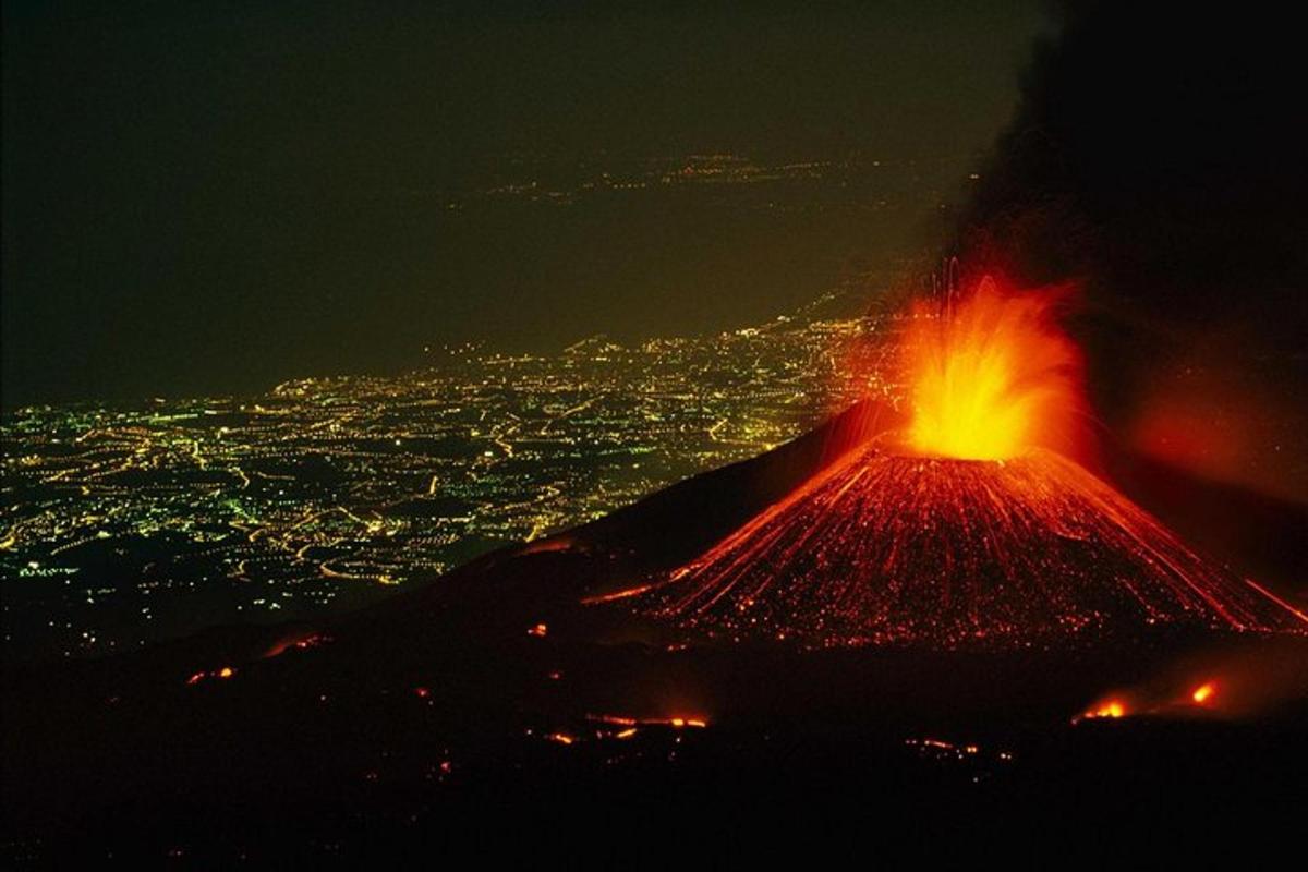 un vulcano di notte con vista su una città