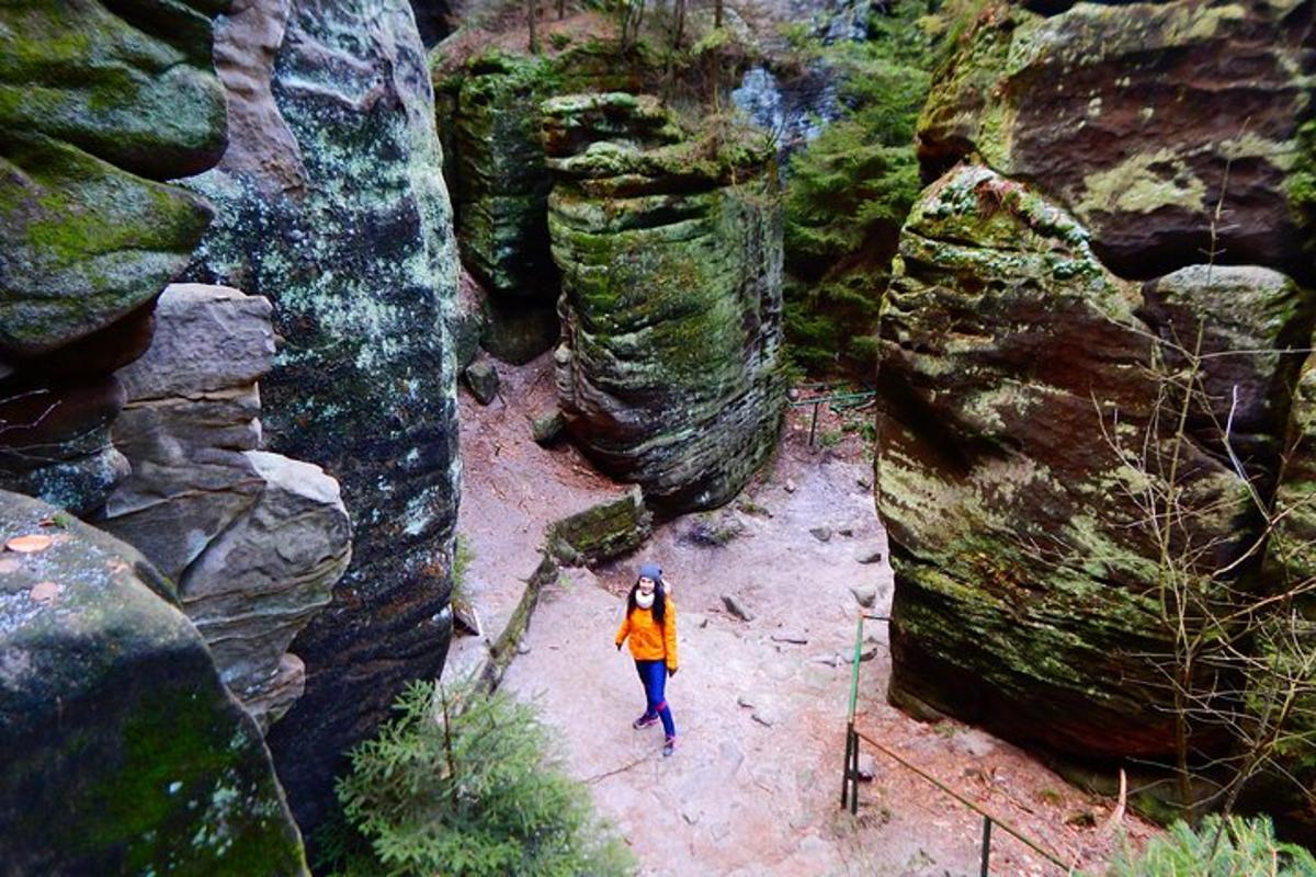 Una mujer camina por un cañón entre rocas.