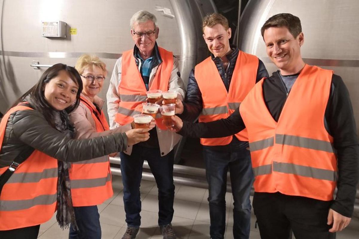 a group of people in orange vests holding drinks