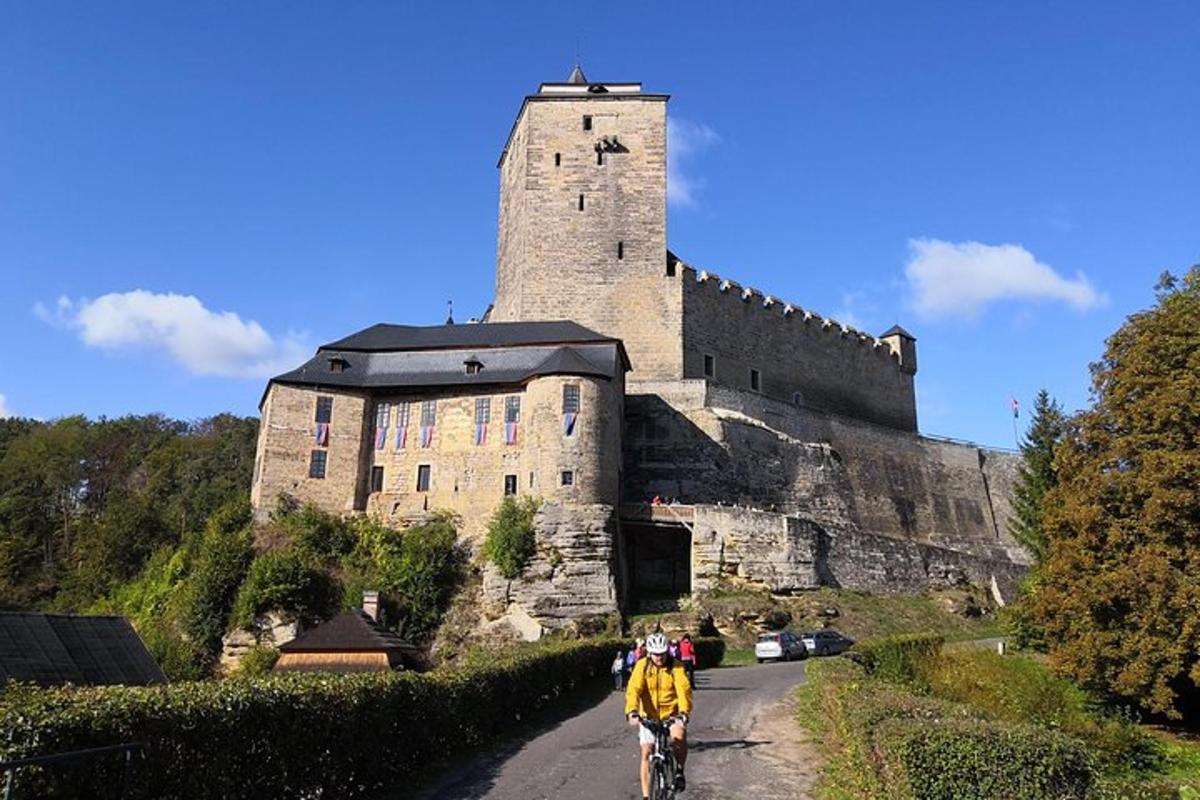 Un hombre andando en bicicleta por una calle frente a un castillo.