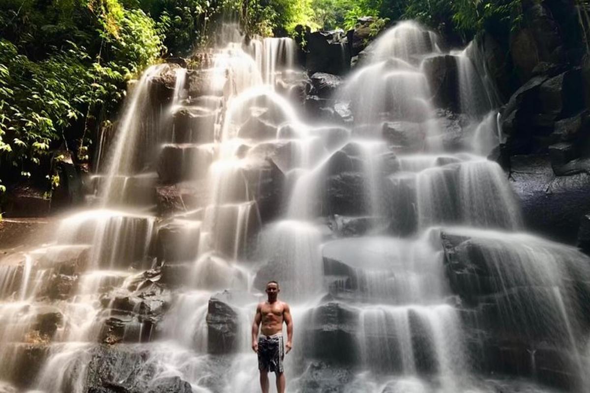 un uomo in piedi davanti a una cascata