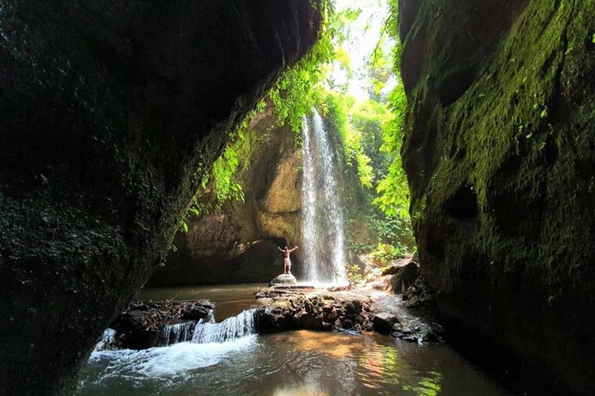 eine Person, die vor einem Wasserfall steht