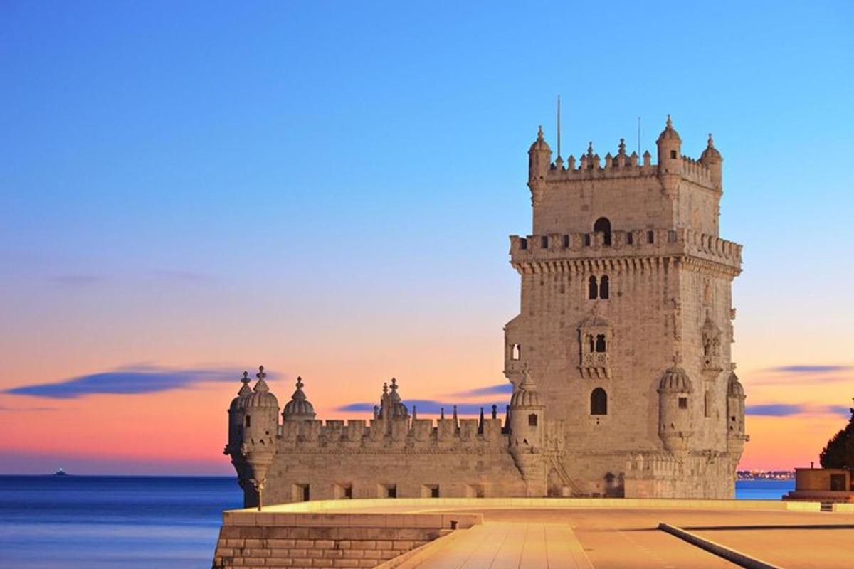 Un edificio de castillo con una puesta de sol al fondo