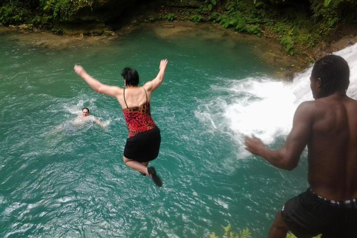 eine Frau, die in einen Wasserfall in einem Fluss springt
