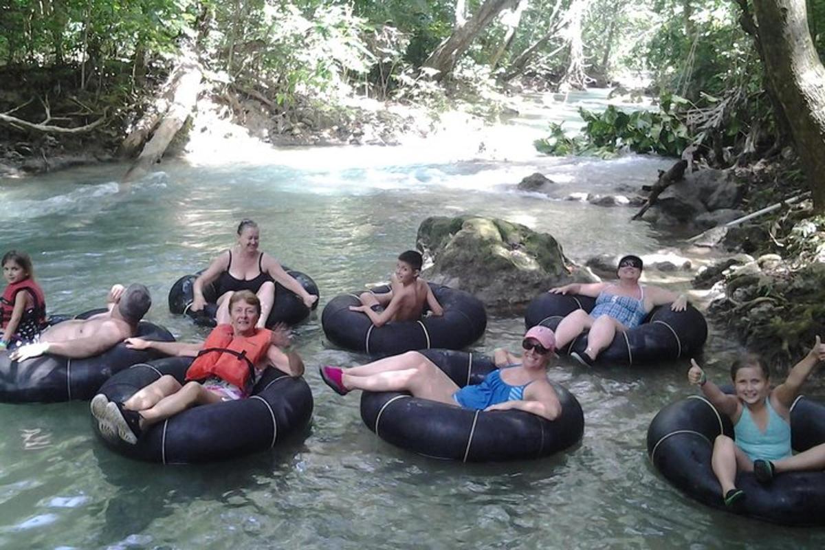eine Gruppe von Menschen, die auf Schläuchen im Wasser reiten