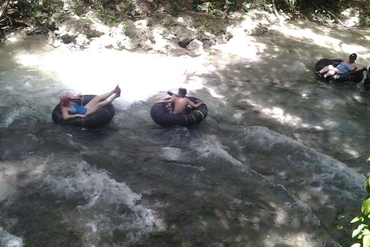 eine Gruppe von Menschen, die auf Schläuchen im Wasser reiten