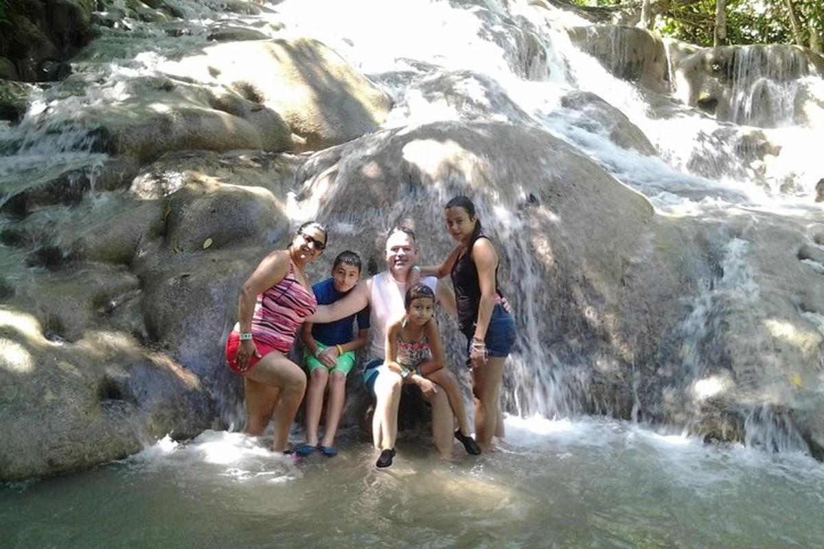Un grupo de personas posando frente a una cascada.