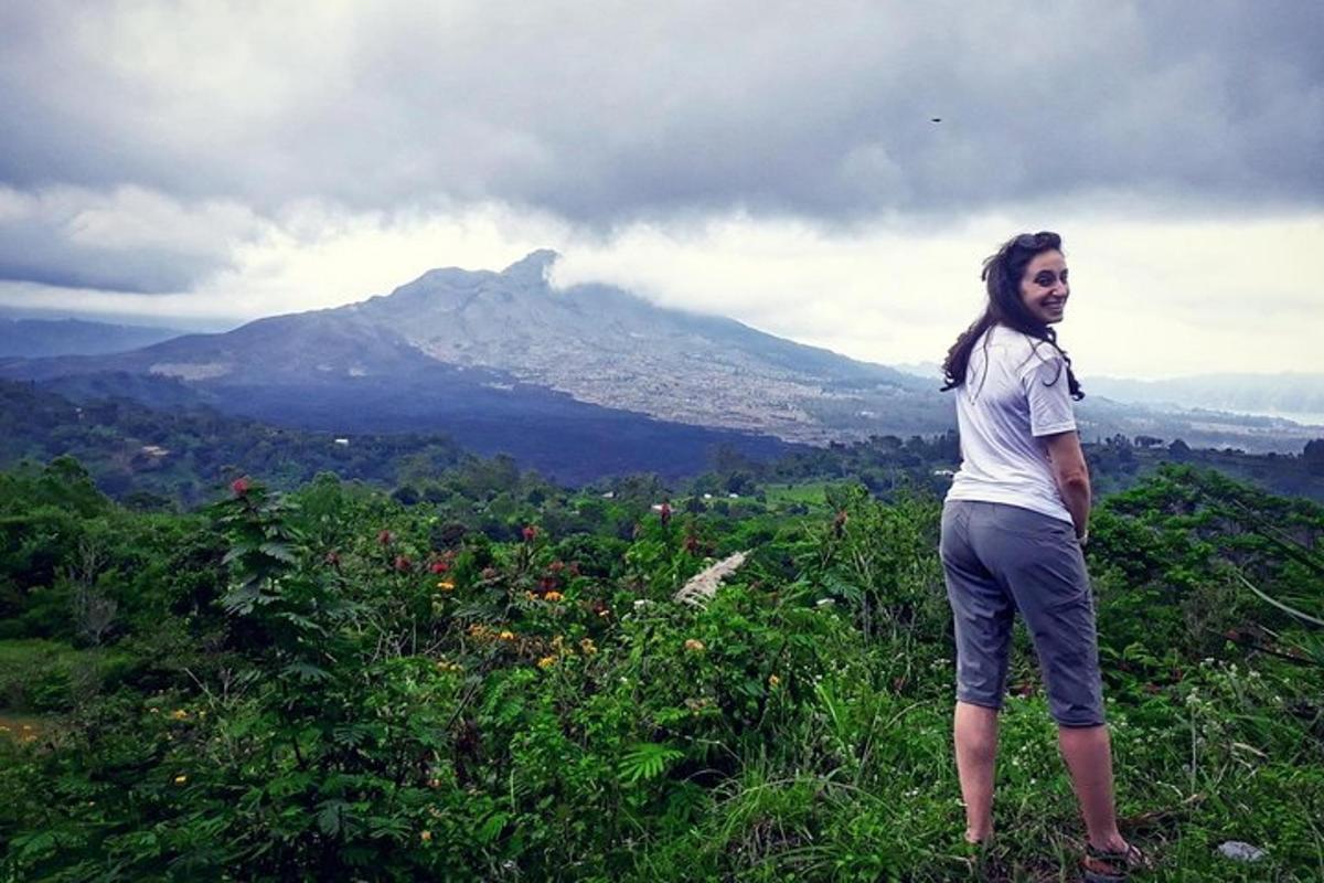 一位女士站在山上，背景是一座山