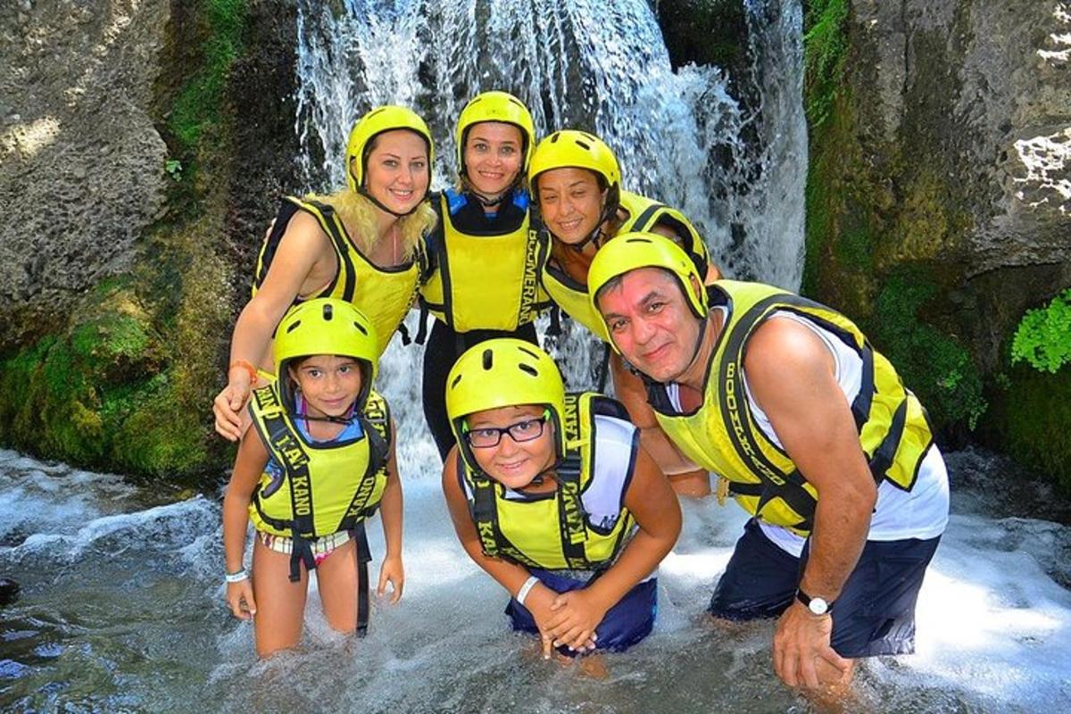 un gruppo di persone con caschi gialli in piedi in una cascata