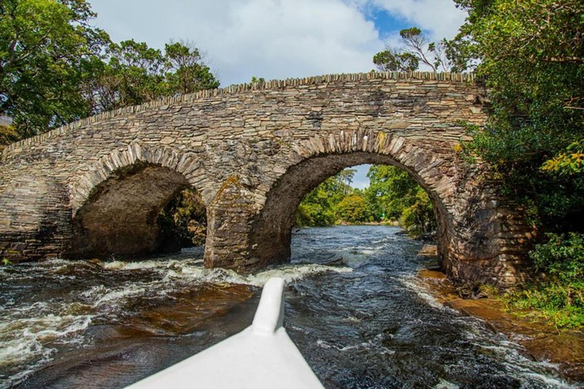 um barco em um rio com uma ponte de pedra