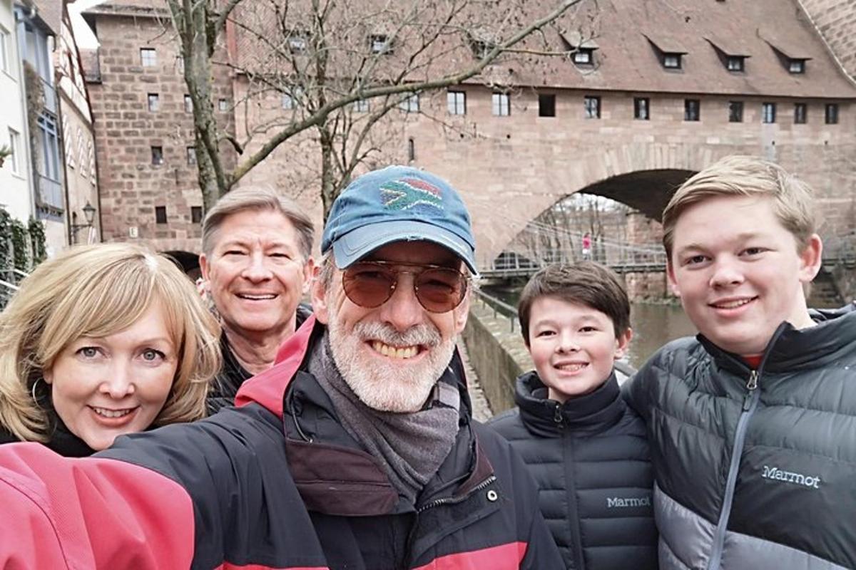 skupina lidí pózujících pro fotografii před mostem