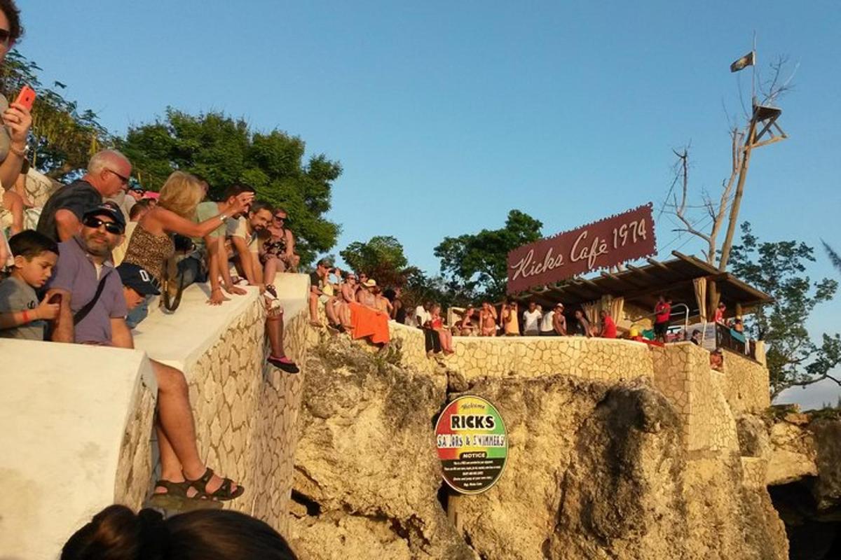 sekumpulan orang duduk di atas tembok batu