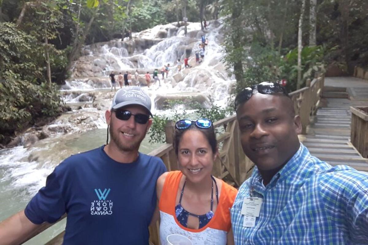 un gruppo di tre persone in piedi davanti a una cascata