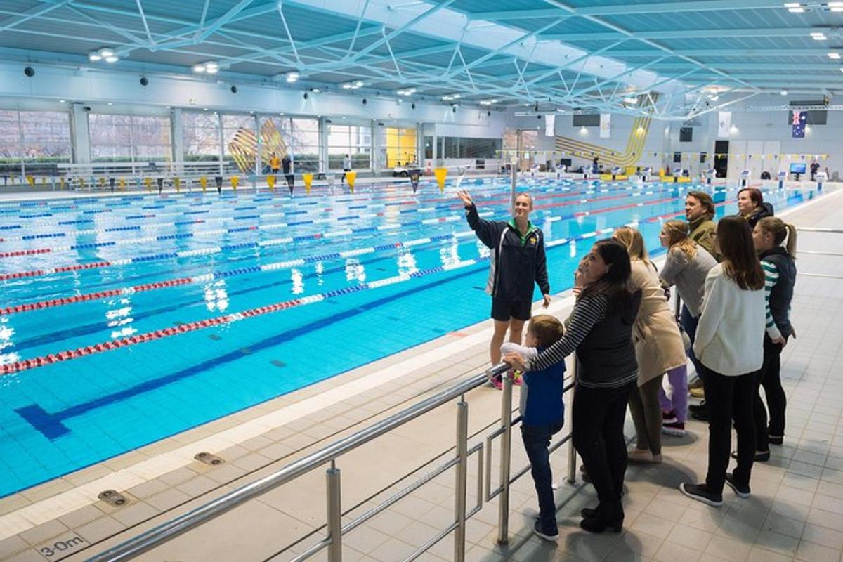a group of people standing next to a swimming pool