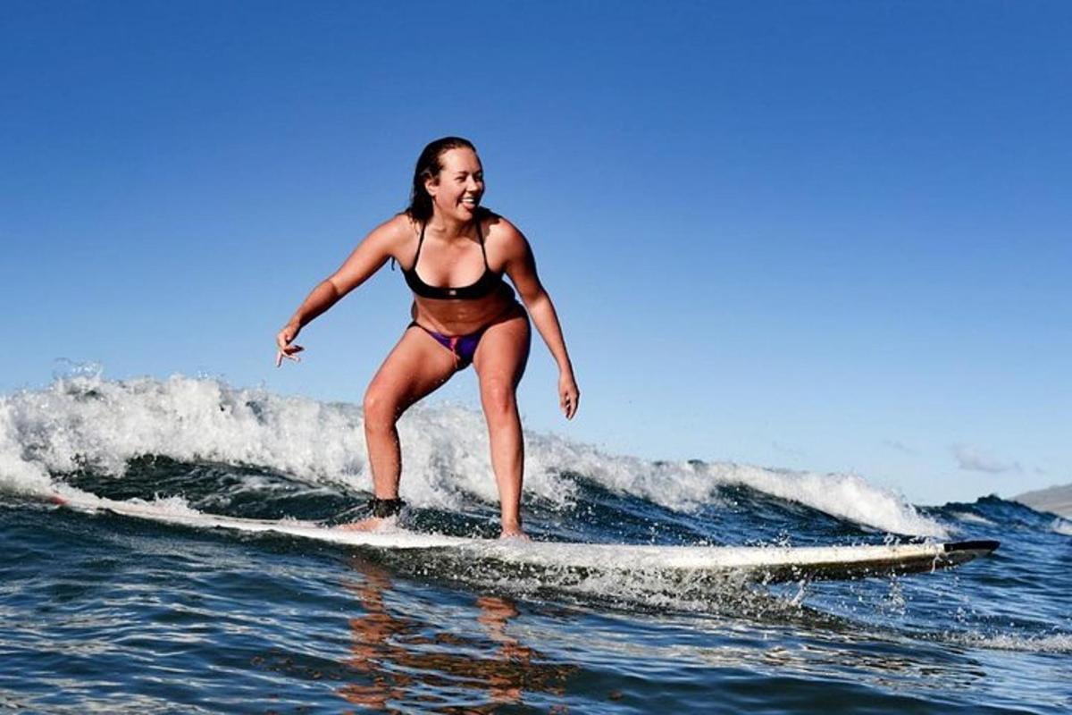uma mulher de biquíni pegando uma onda em uma prancha de surfe