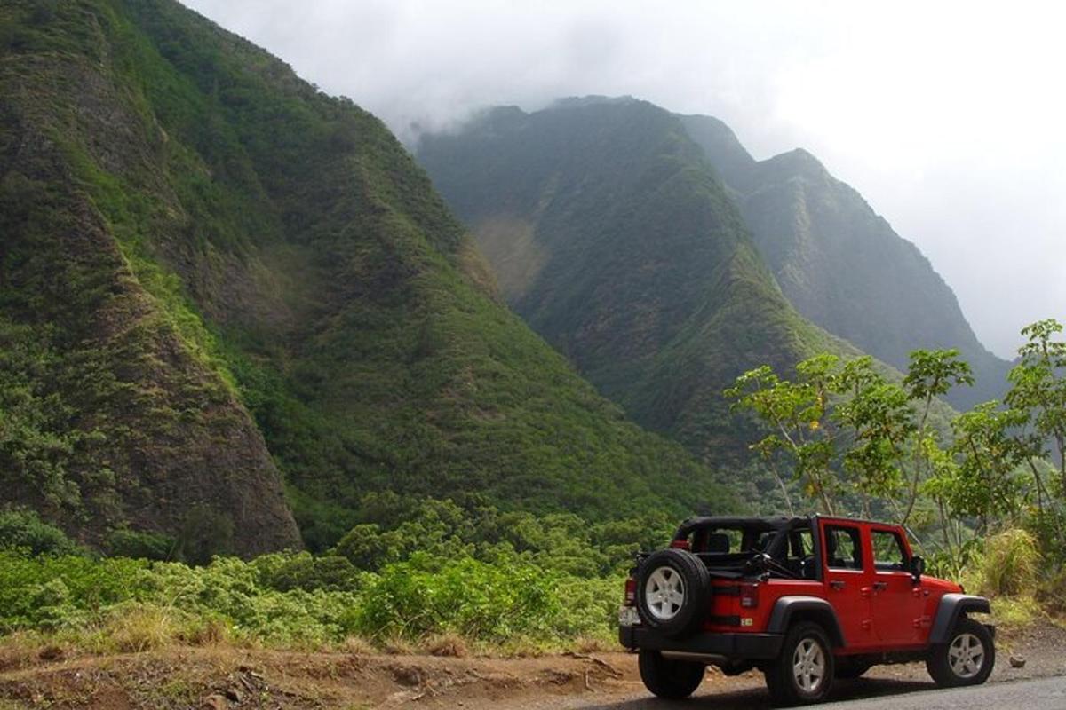 un jeep vermell conduint per una carretera de muntanya