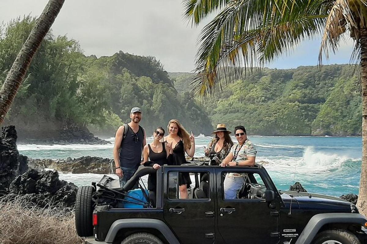 un grupo de personas en un jeep en la playa