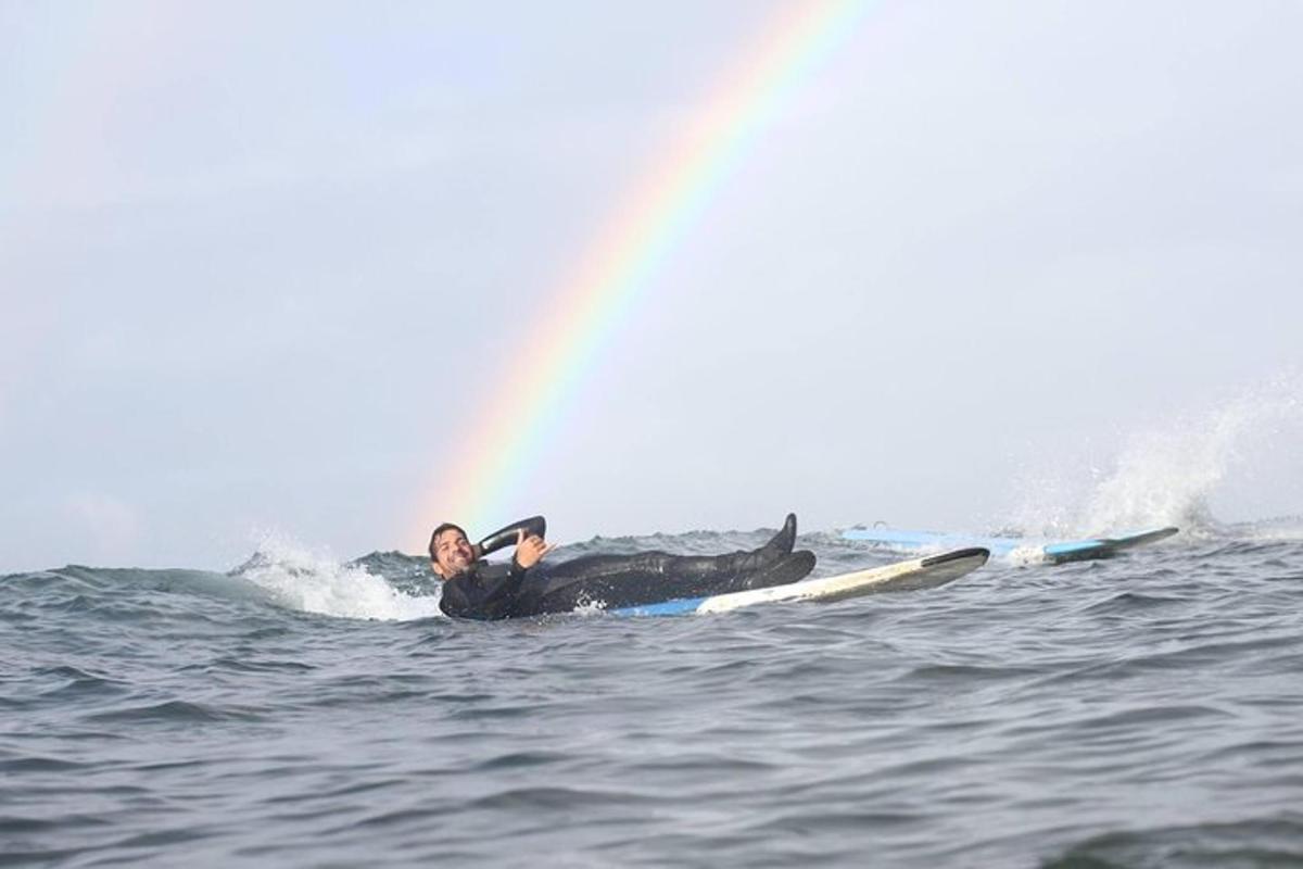 muž ležící na surfovém prkně v oceánu