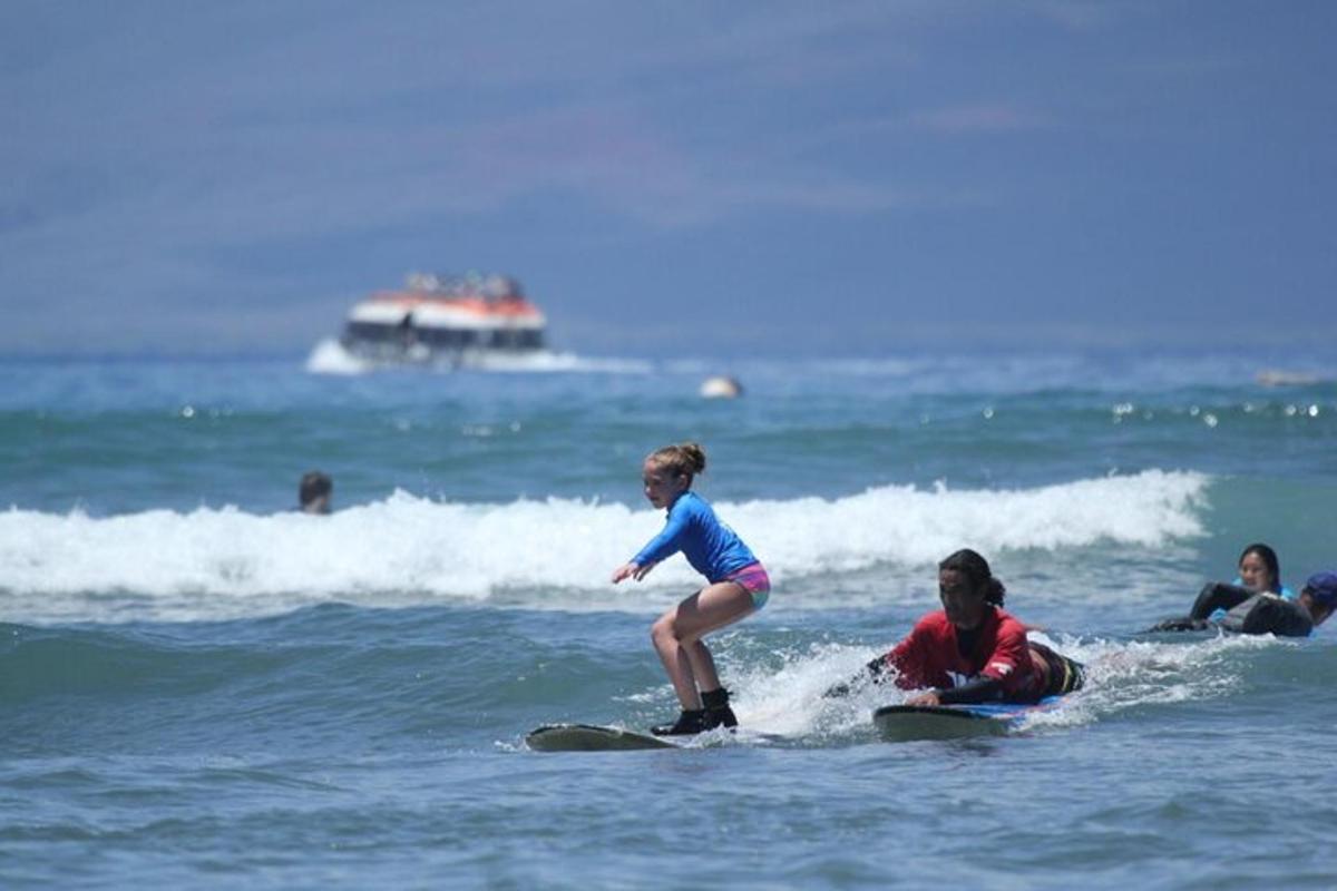 a young girl riding a wave on a surfboard in the ocean