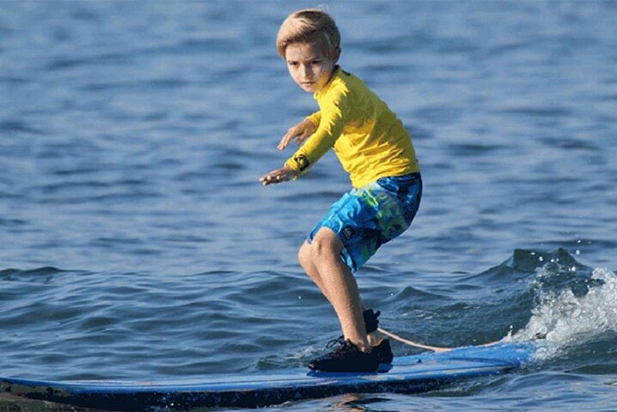 a young boy on a surfboard in the water