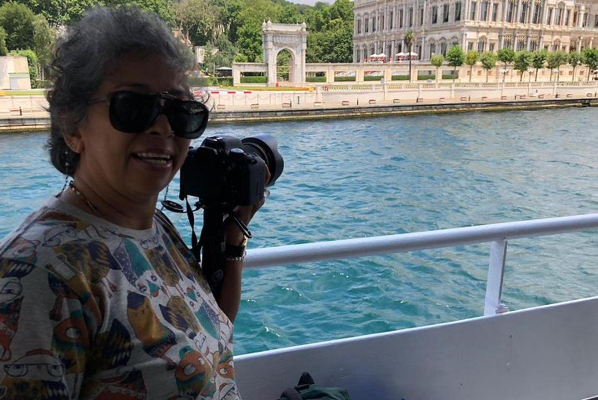 žena se slunečními brýlemi držící fotoaparát na lodi