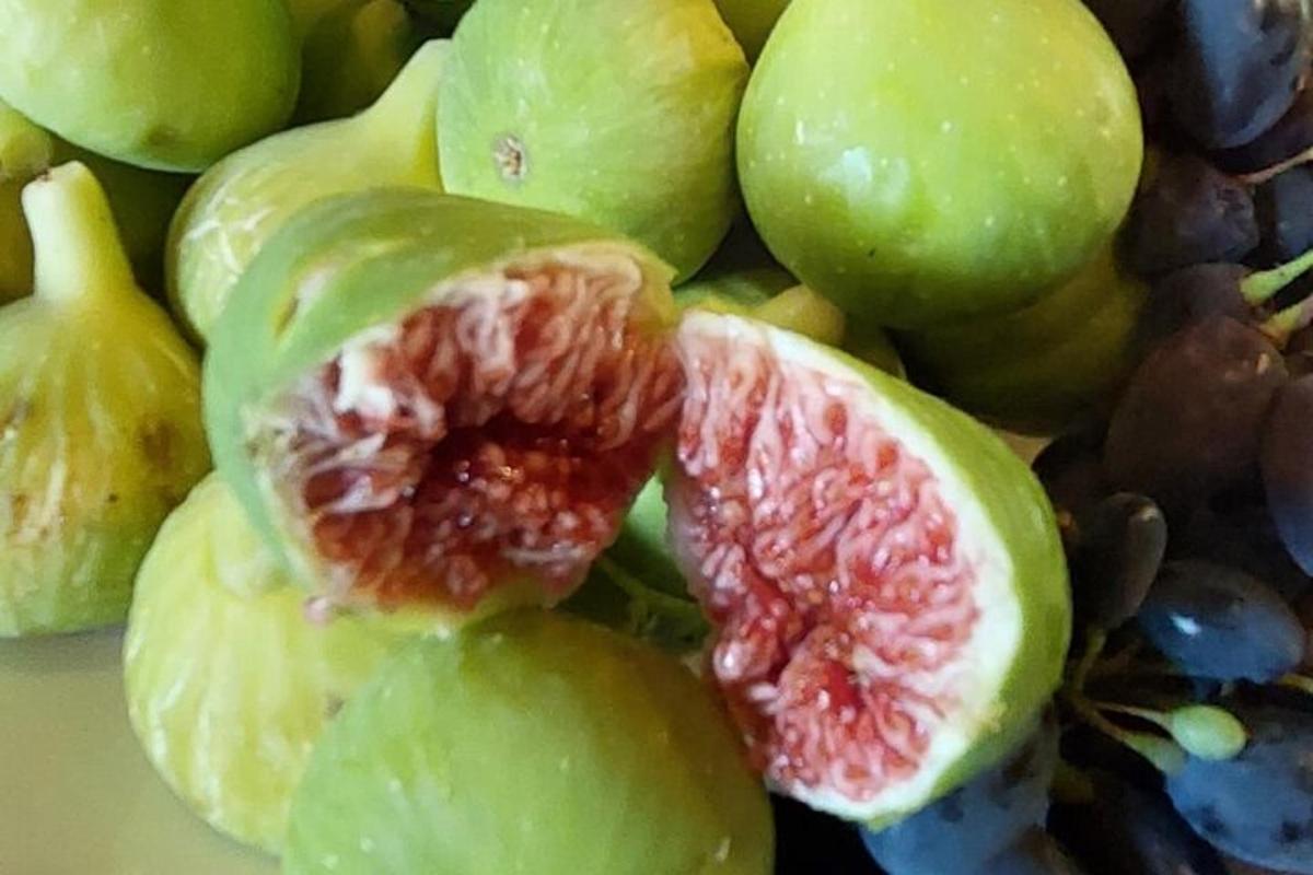 un gruppo di uva verde con un pompelmo tagliato aperto