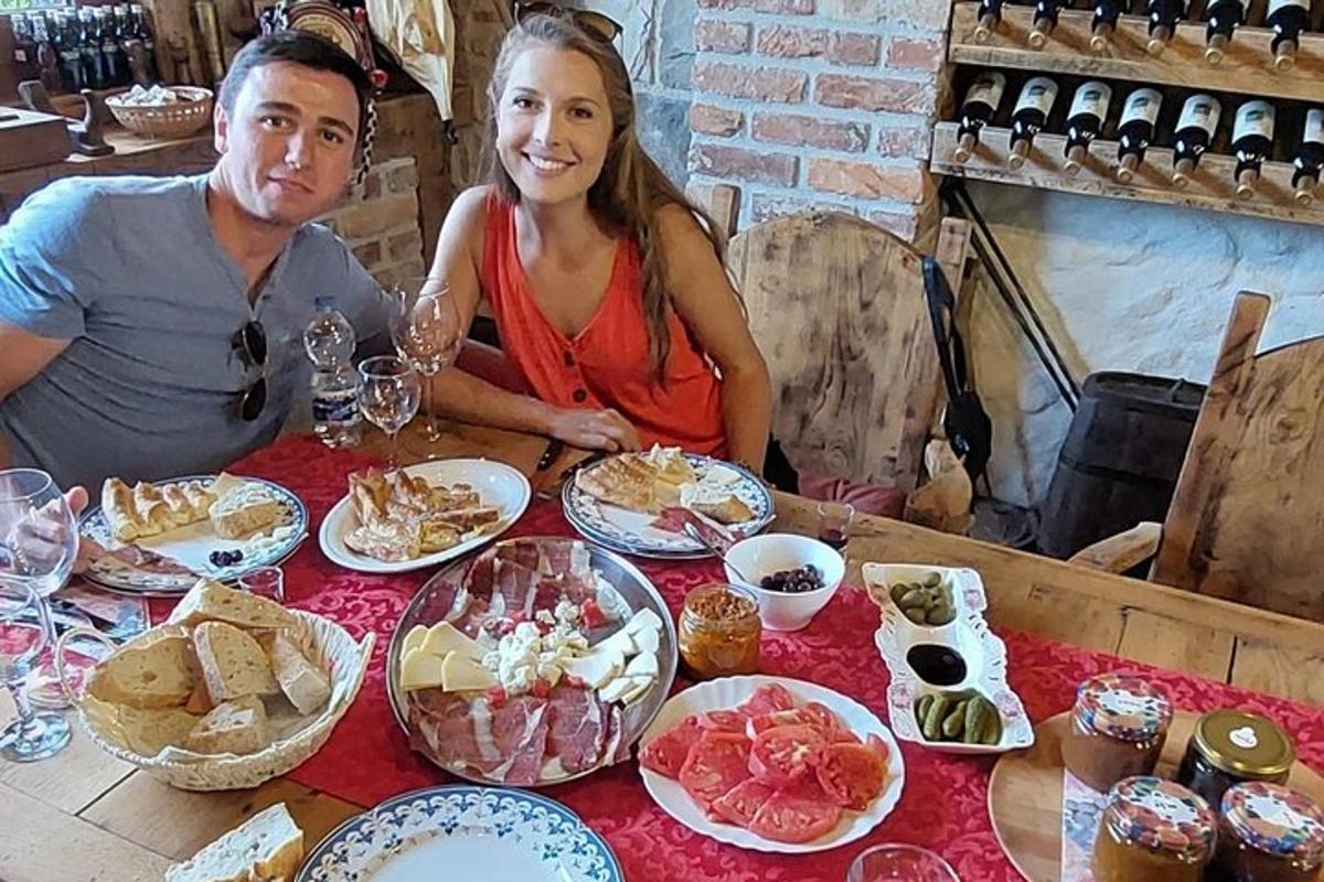 Un hombre y una mujer sentados en una mesa con comida.