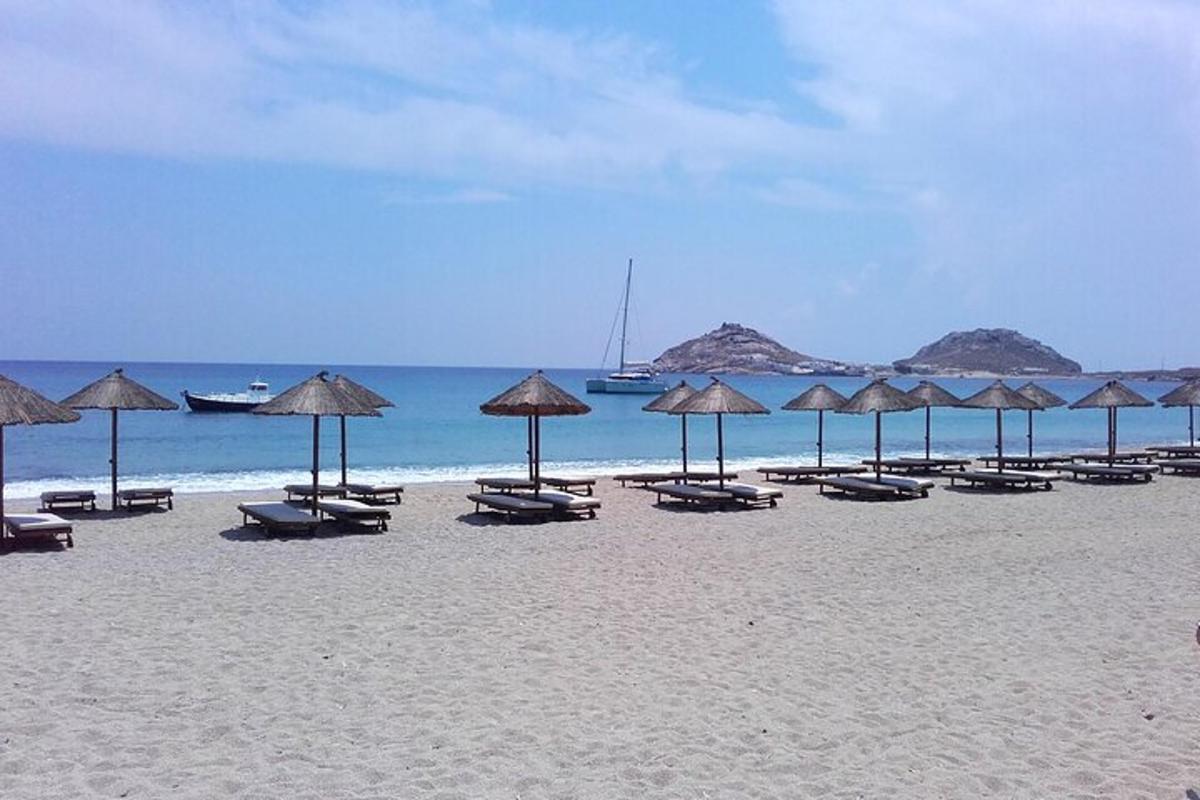 egy strand sok székkel és napernyővel a homokban