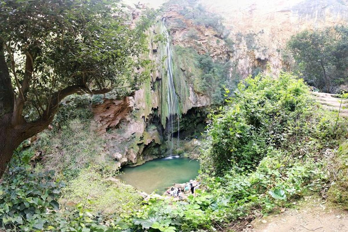 a waterfall in a canyon with a pool of water