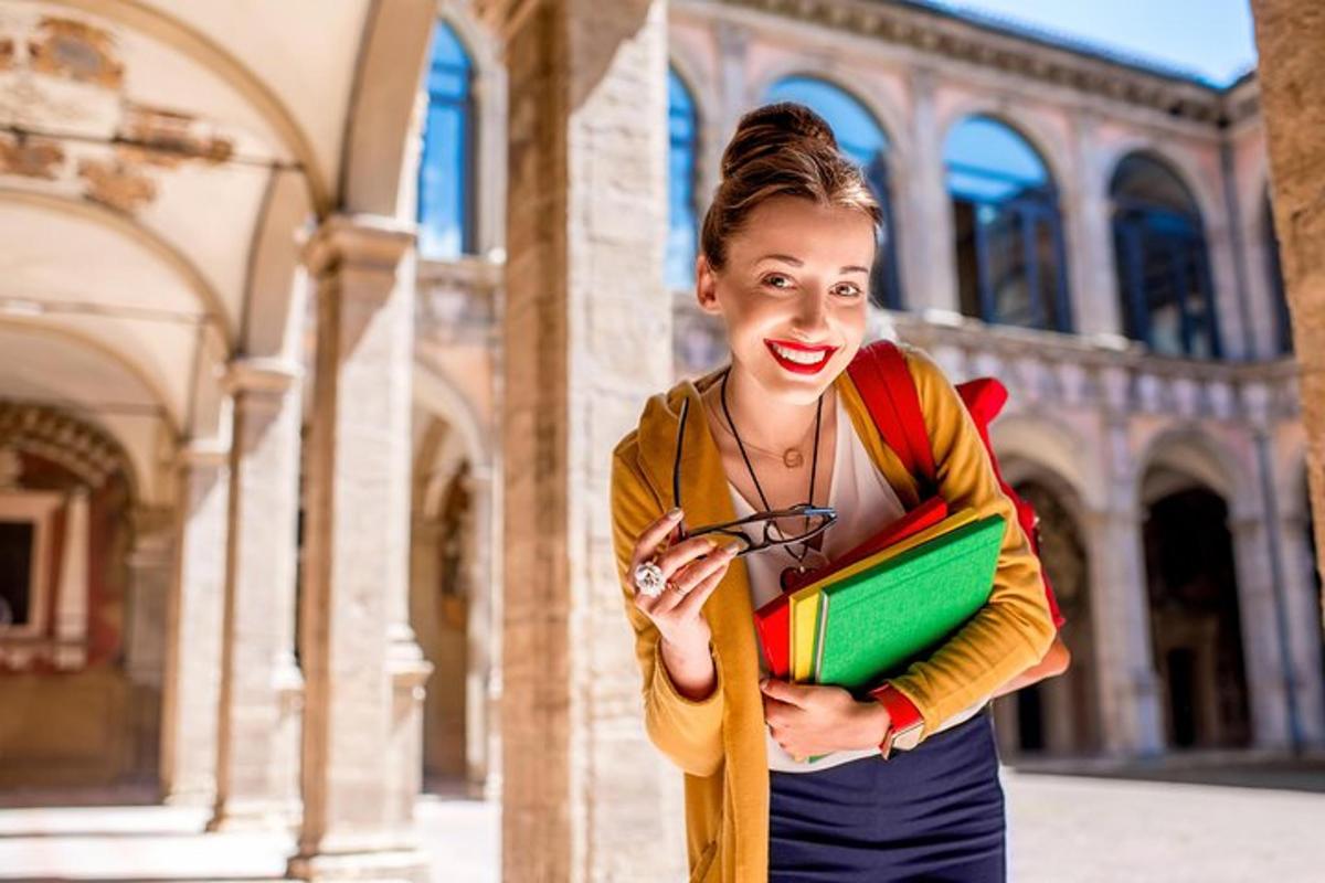 a woman standing in front of a building holding books