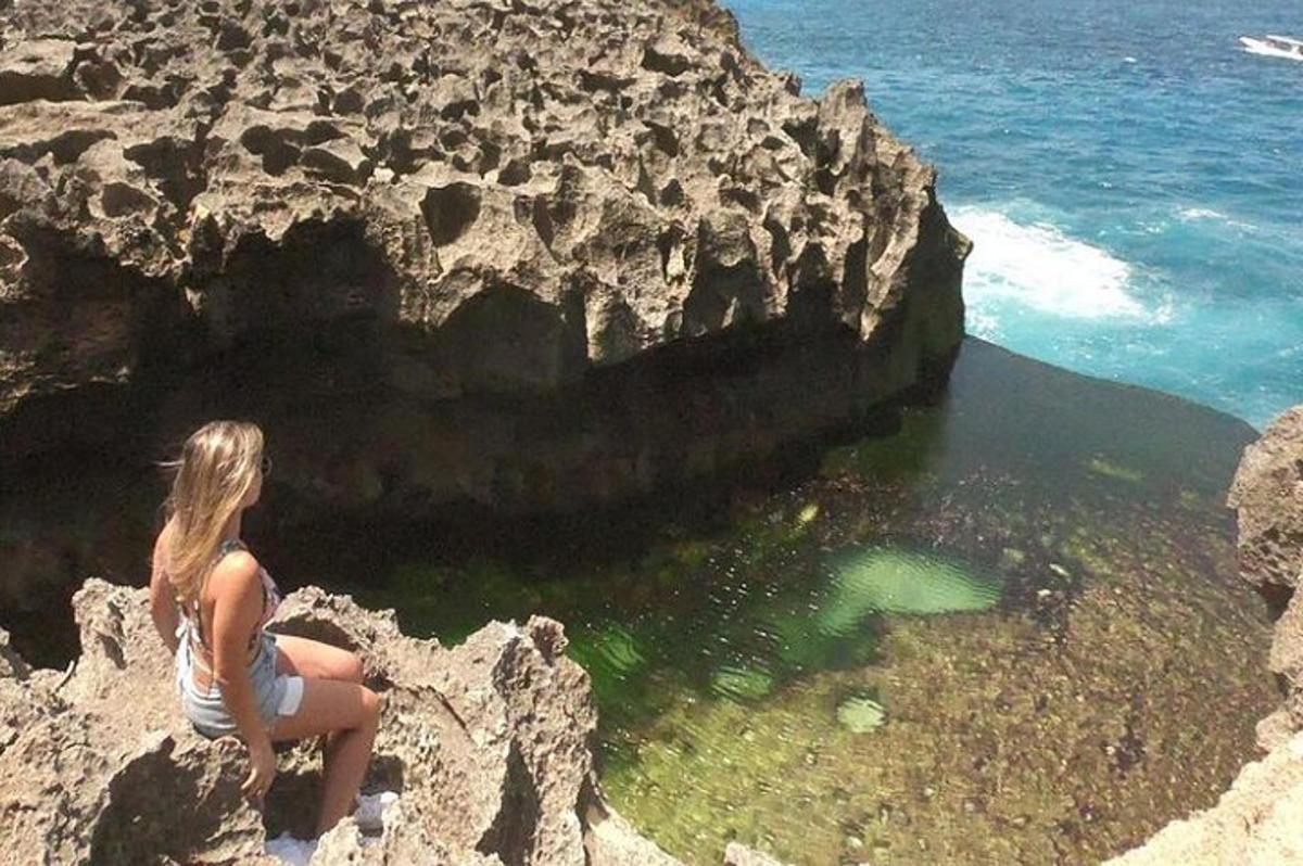 una donna seduta su una roccia vicino all'oceano
