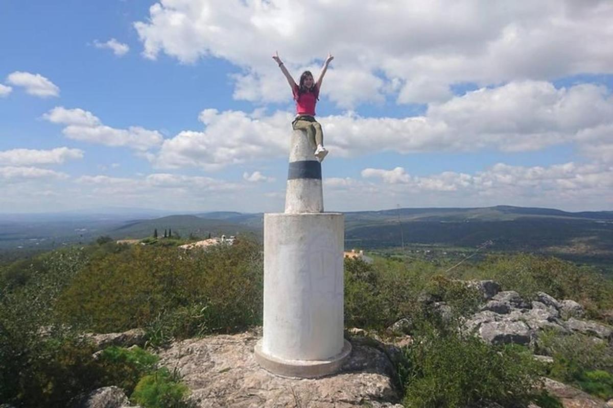una donna in piedi in cima a un faro su una montagna