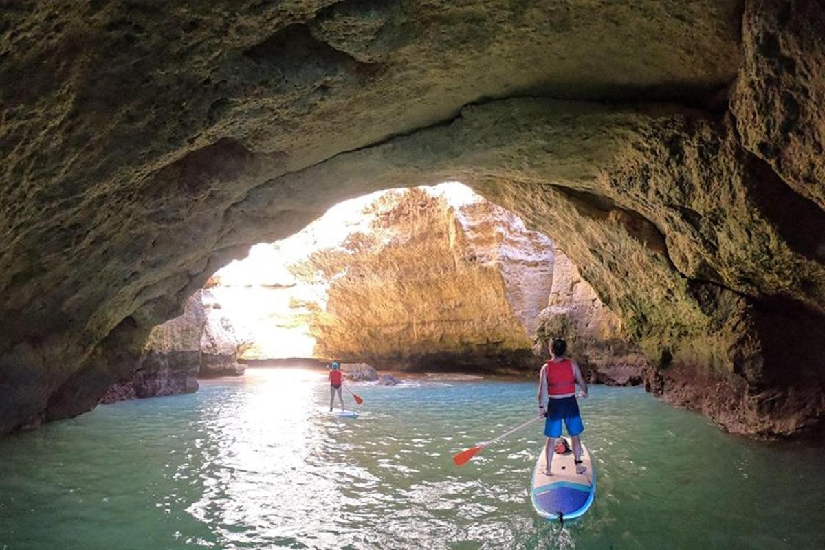 due persone su una tavola da paddle in una grotta