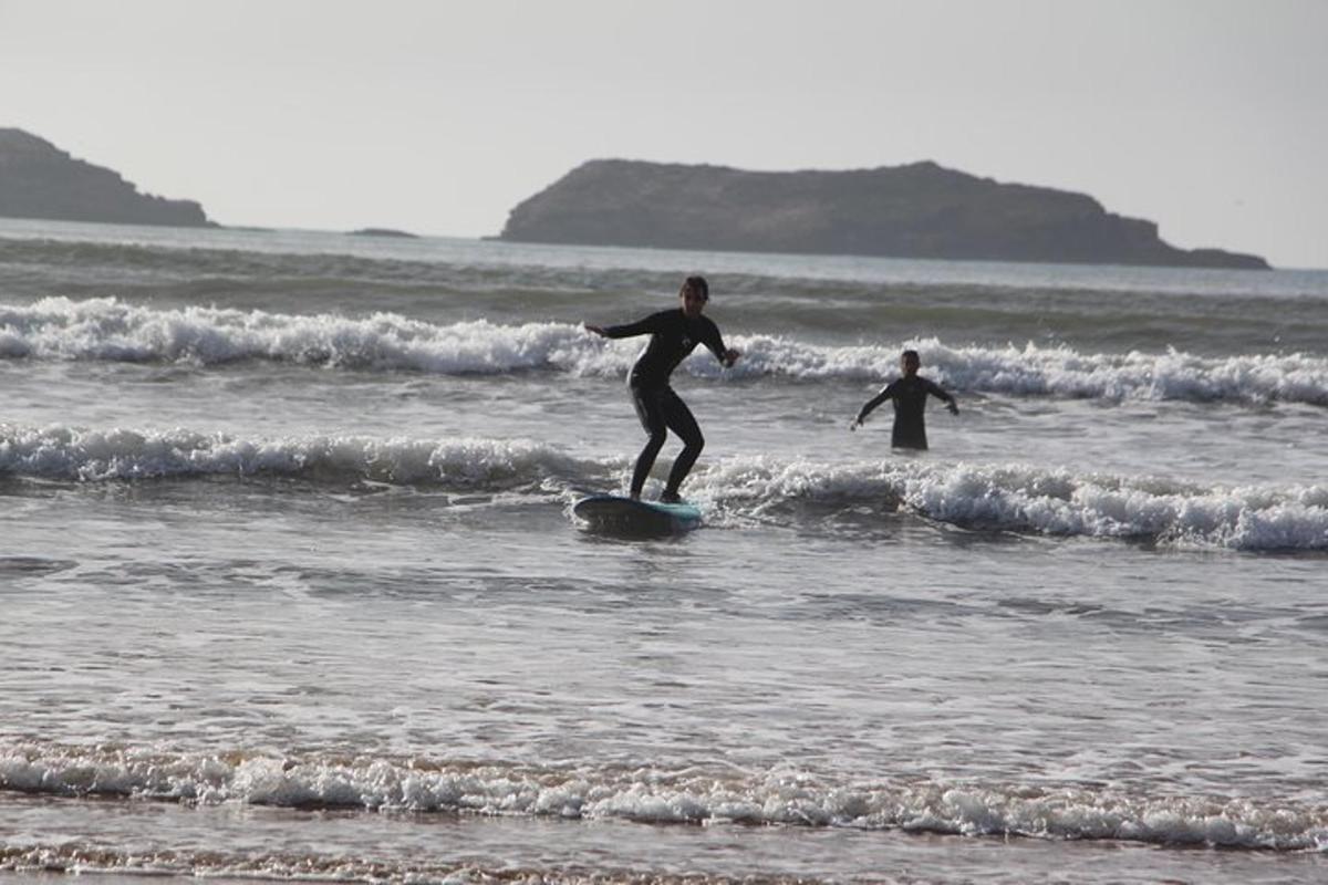 two people riding waves on surfboards in the ocean
