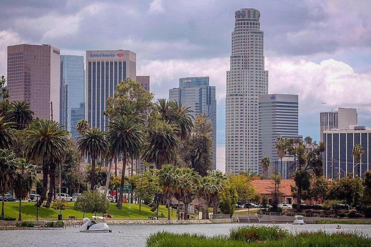 a city skyline with palm trees and a body of water