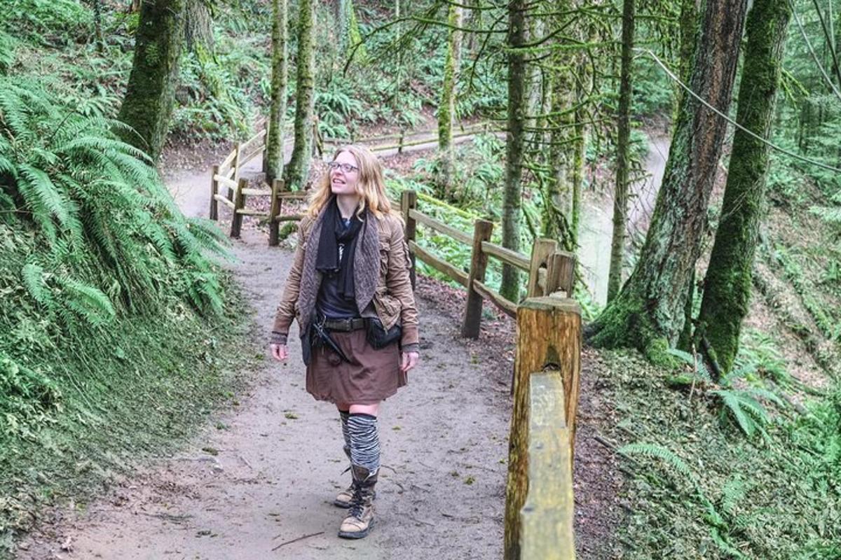 a woman walking on a trail in the woods