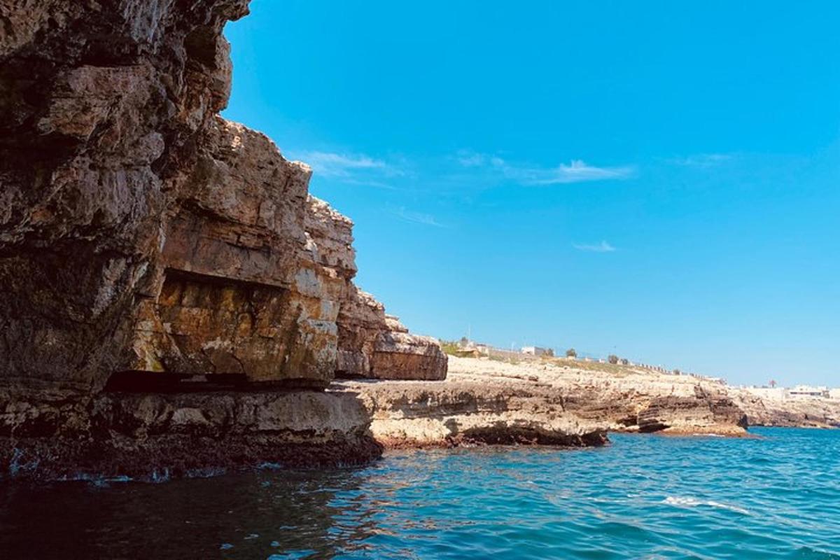pemandangan pantai berbatu dengan air biru