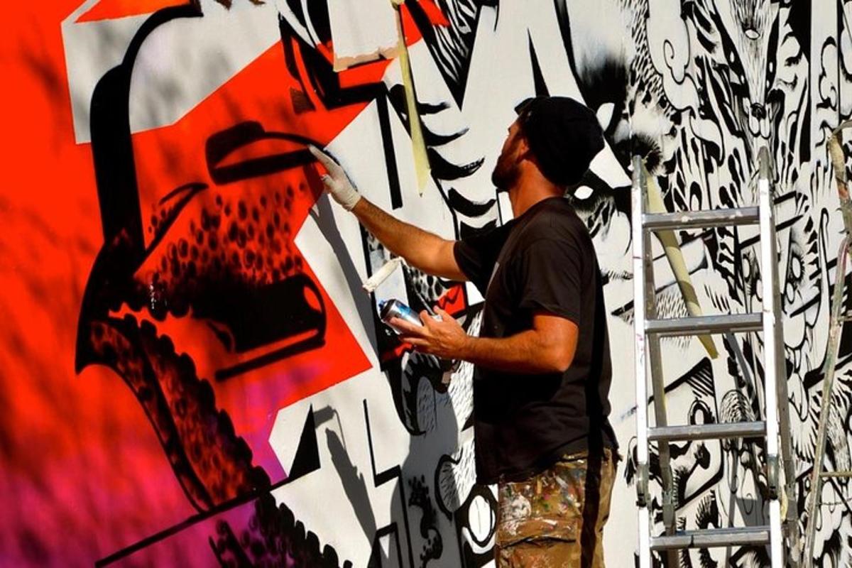 a man painting a mural on a wall