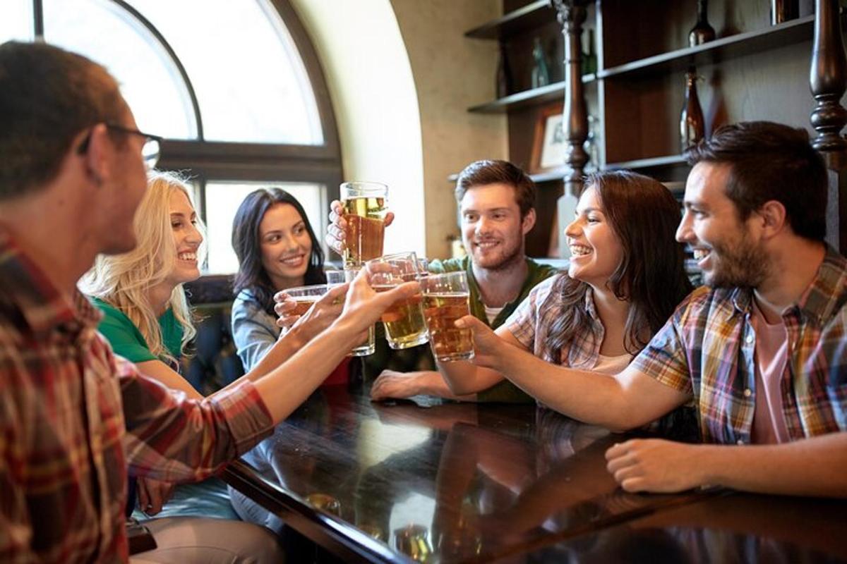 sekumpulan orang duduk di sekeliling bar sambil minum bir