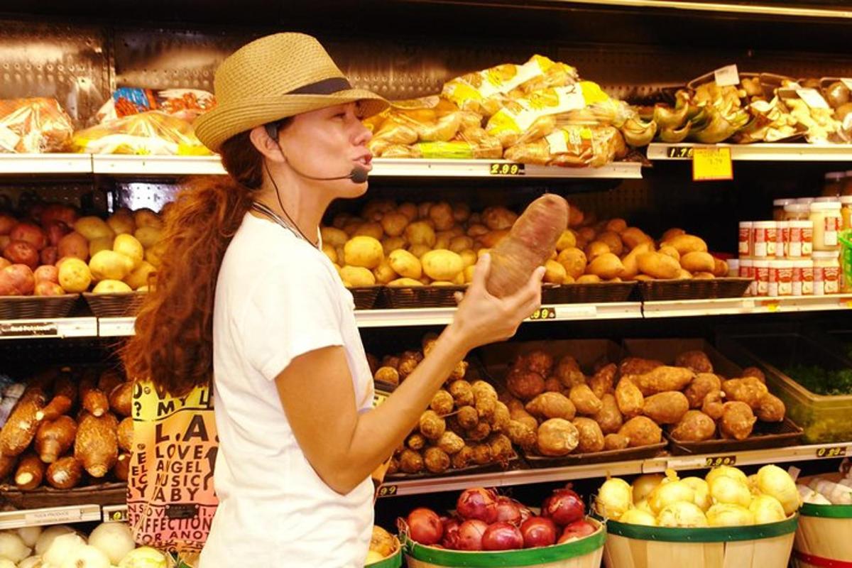 a woman in a grocery store holding a hot dog