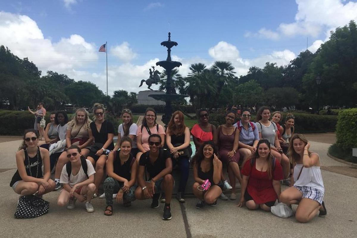 a group of people posing for a picture in front of a fountain