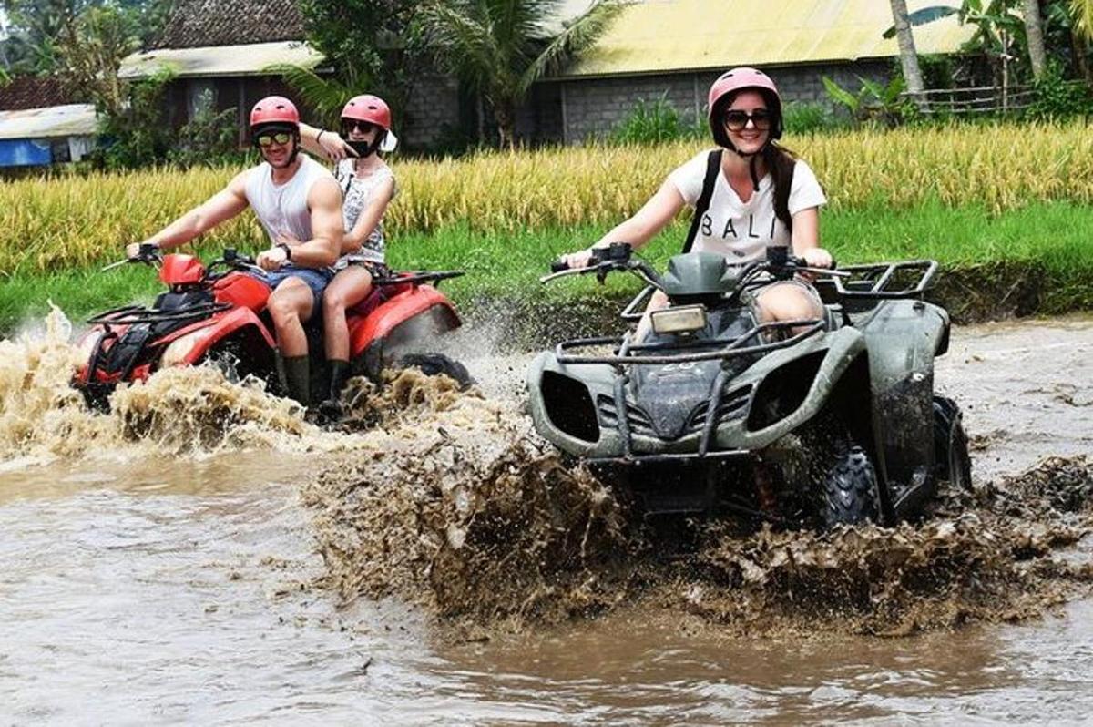 a group of people riding on atvs through the water