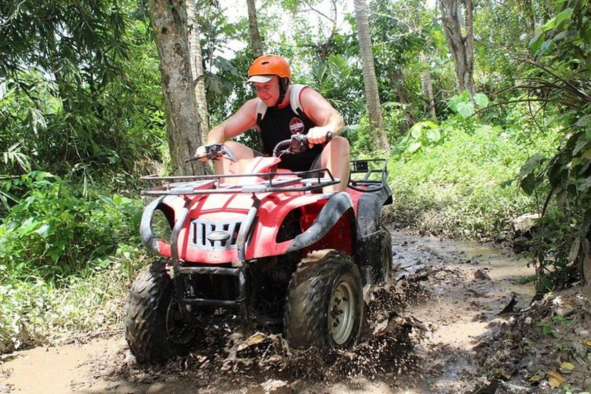 a man riding a atv down a dirt trail