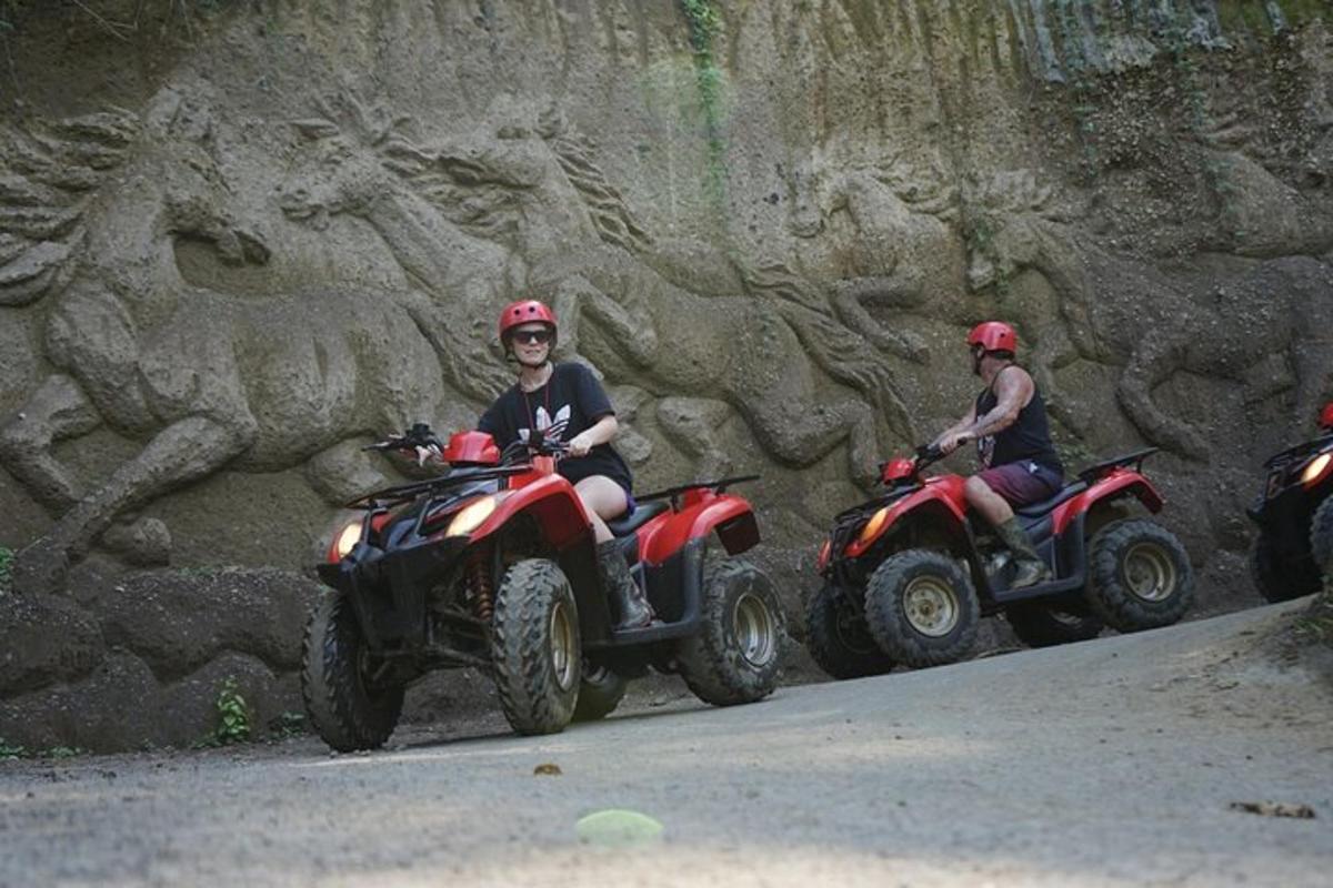 a group of people riding atvs against a rock wall